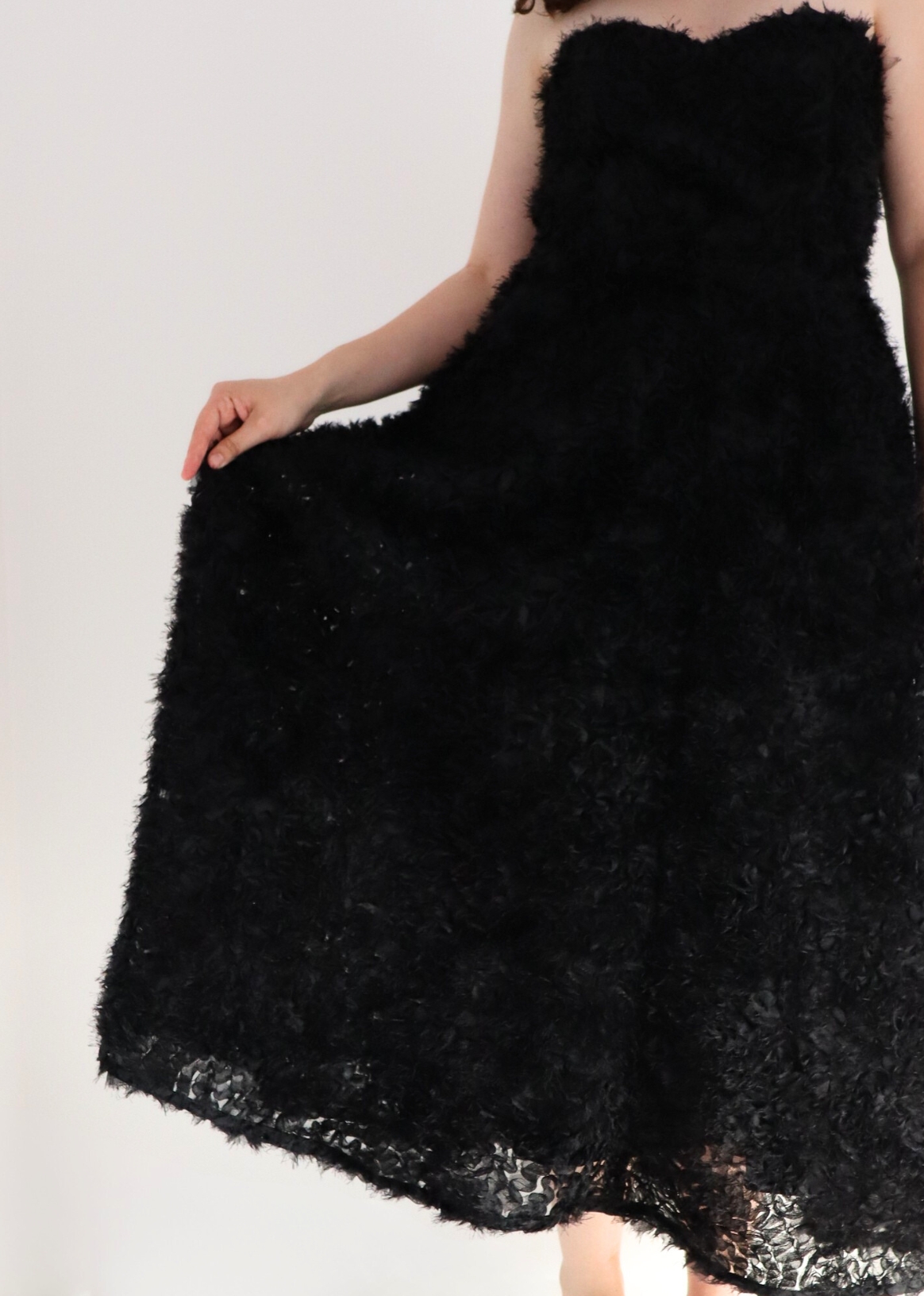 Detail of sweetheart neckline on timeless midi black dress with embroidered tulle