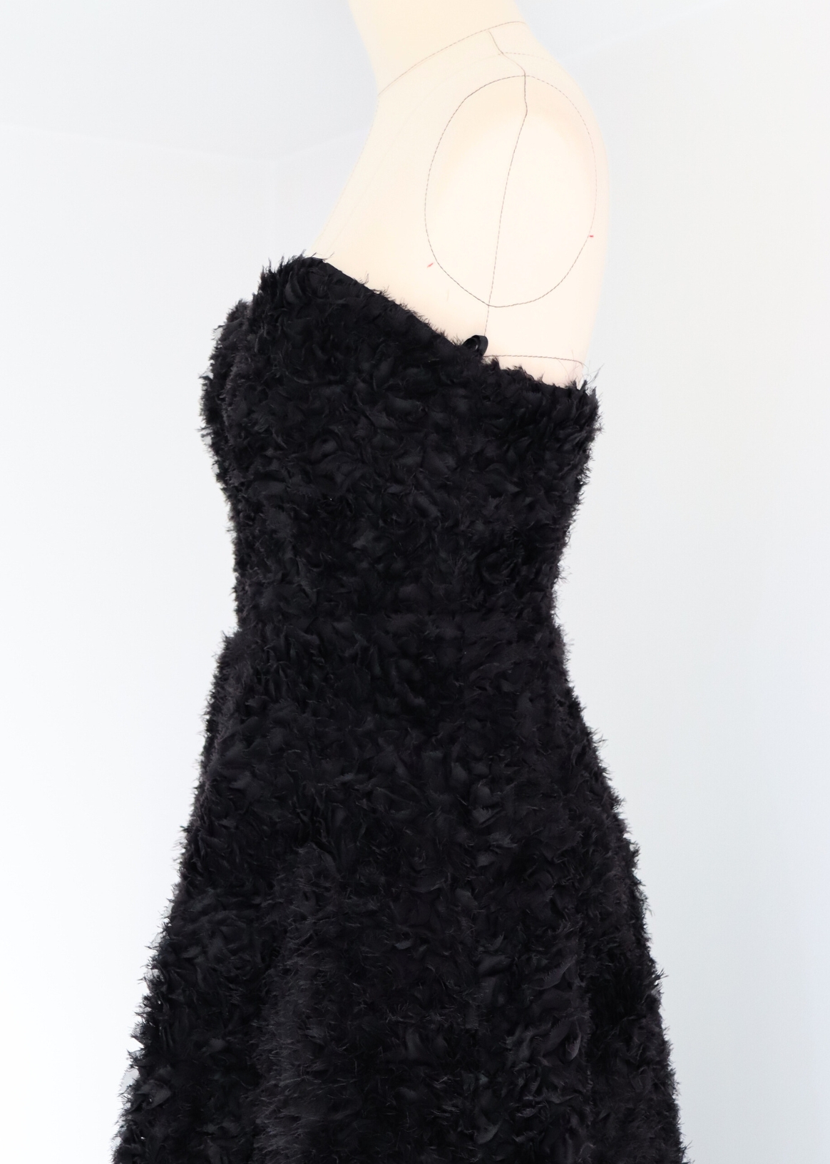Side view of timeless midi black dress featuring satin ribbons and body-shaping corset