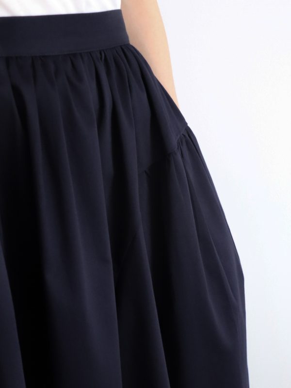 Close-up showing texture and quality of navy cotton fabric on A-line skirt