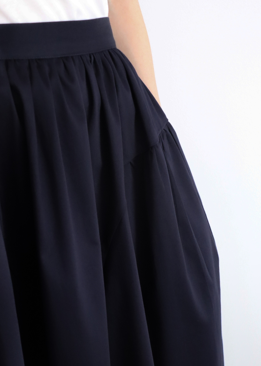 Close-up showing texture and quality of navy cotton fabric on A-line skirt