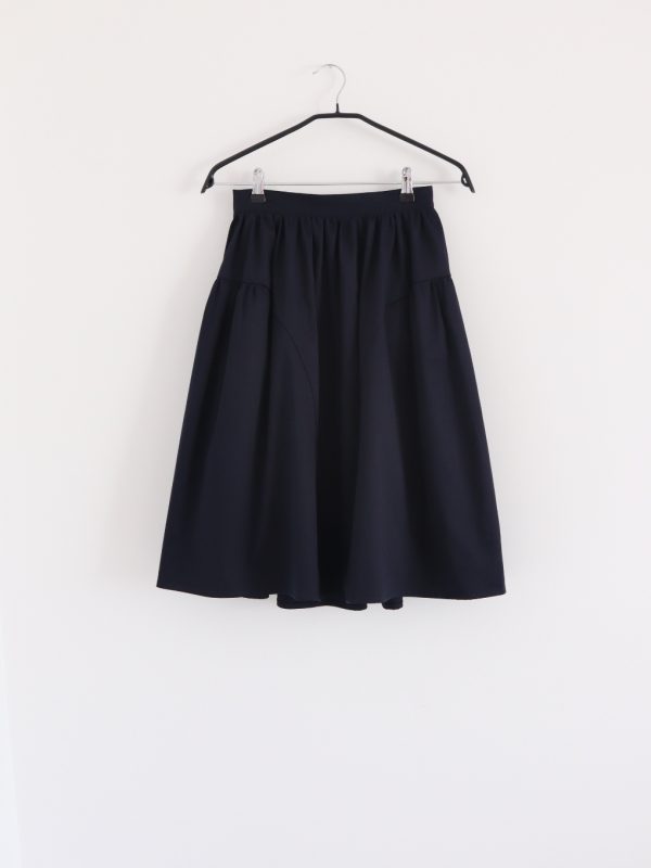 Front view of navy elegant cotton A-line skirt with gathered waist and panelled design