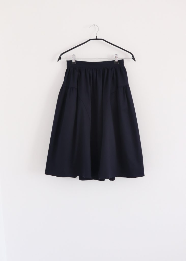 Front view of navy elegant cotton A-line skirt with gathered waist and panelled design