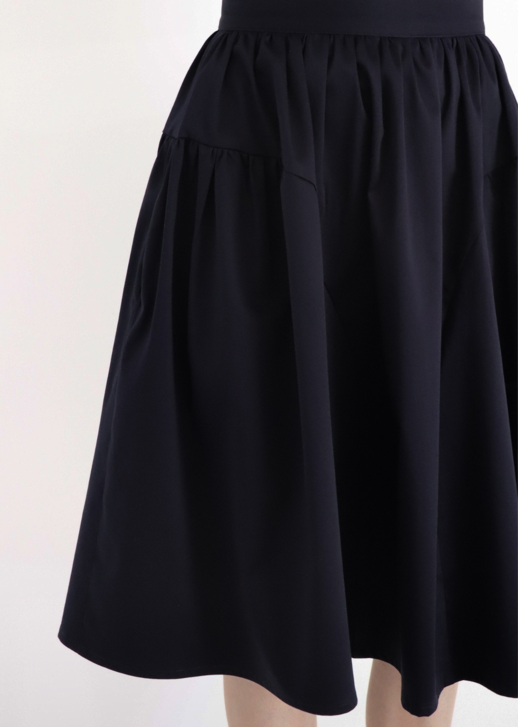 Navy elegant cotton A-line skirt worn by model, front view, knee-length flared silhouette