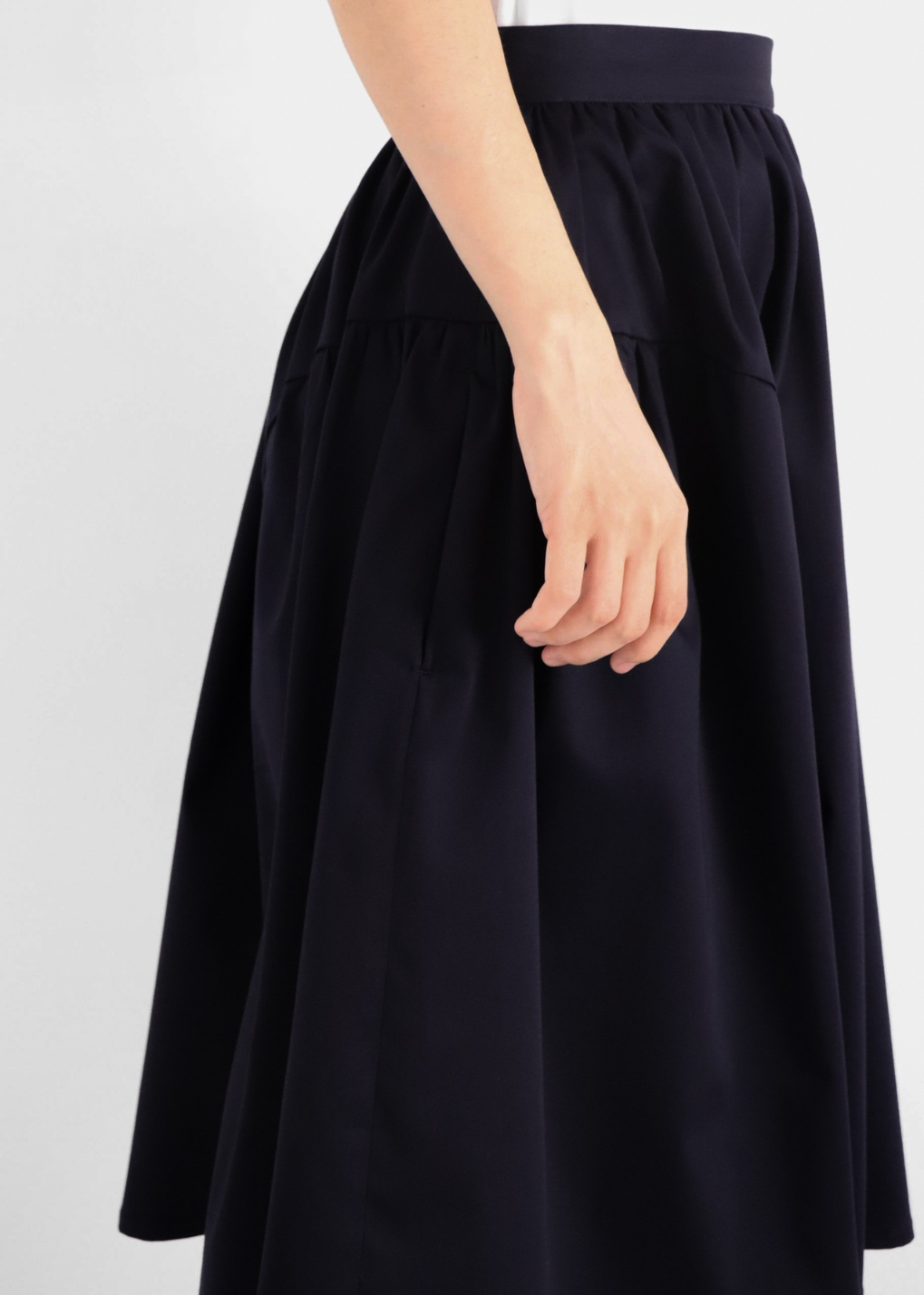 Side view of navy elegant cotton A-line skirt on model showing flared shape