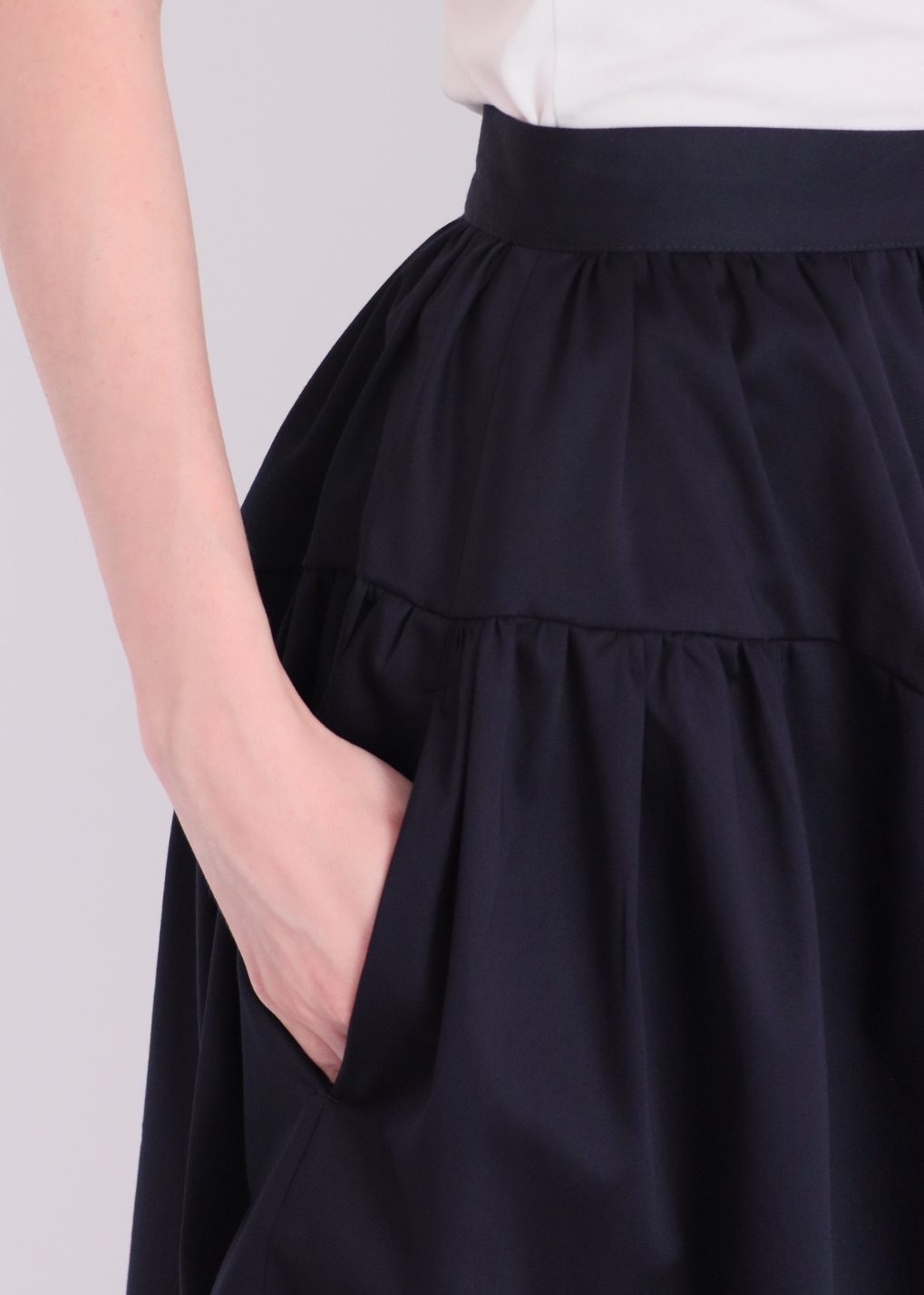 Detail of pockets on navy elegant cotton A-line skirt with panelled design