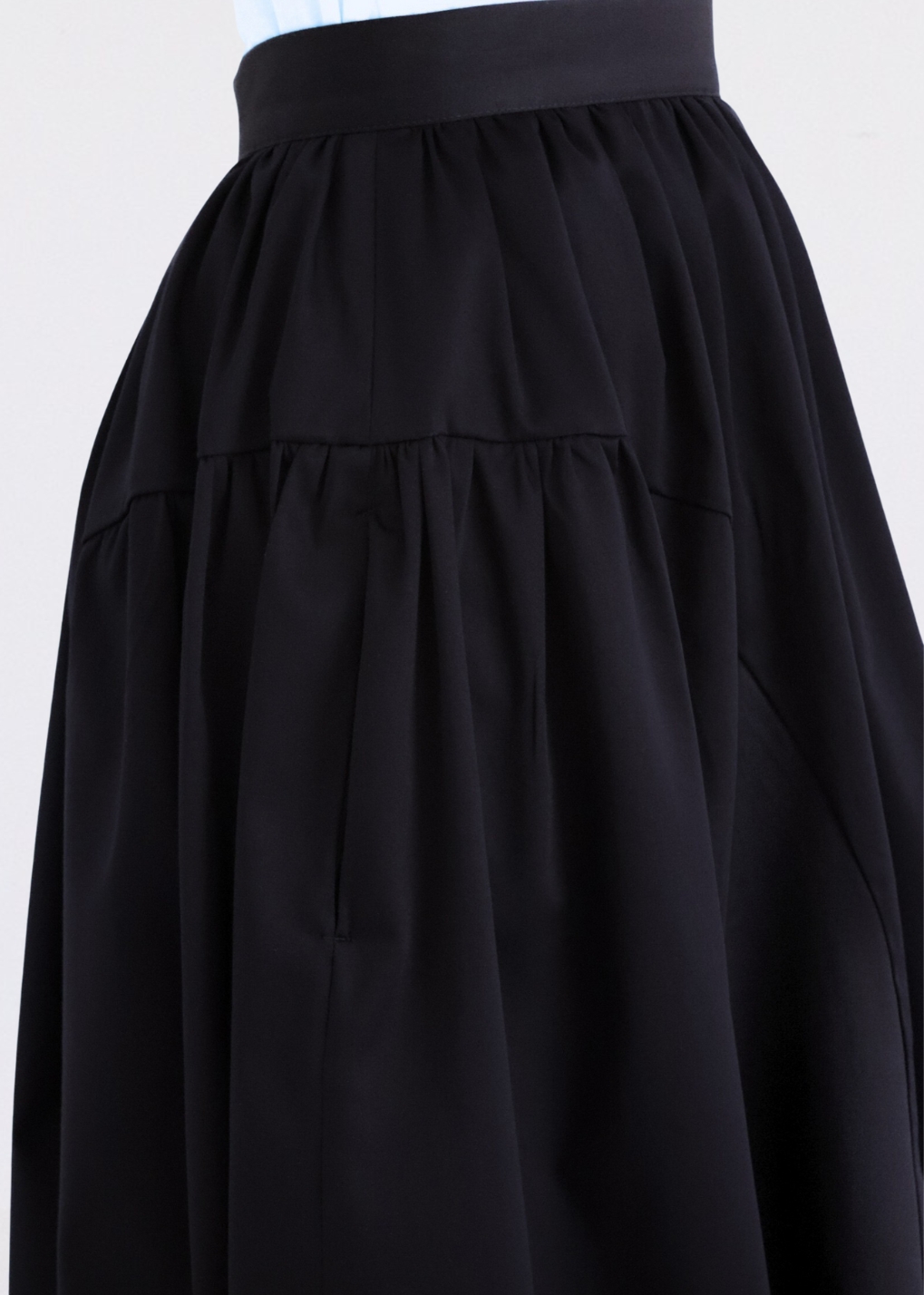 Side view of navy elegant cotton A-line skirt highlighting panelled design and flared silhouette