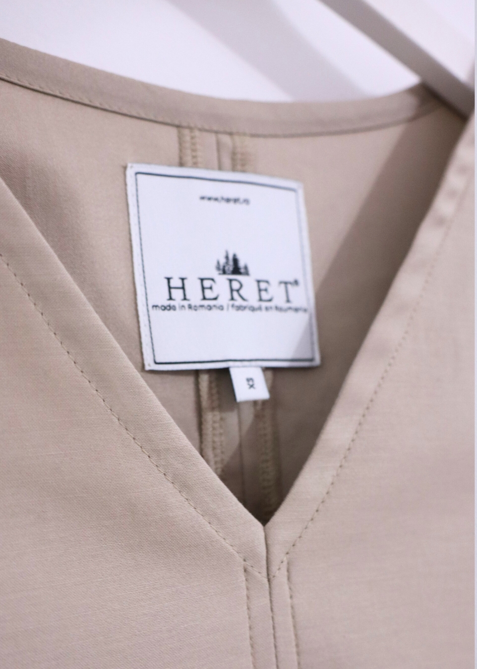 Close-up detail of HERET beige cotton fall dress fabric and texture