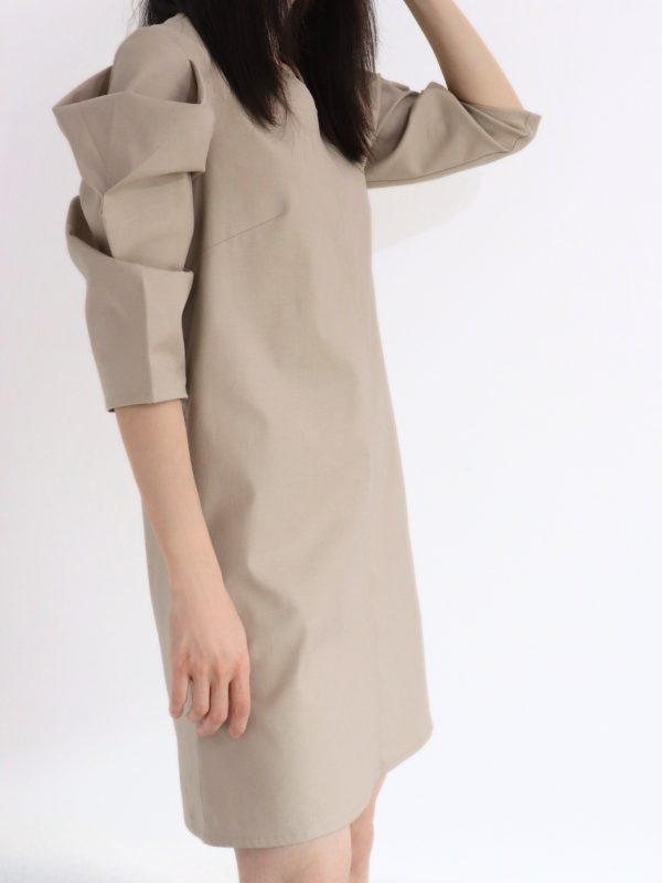 Side view of HERET beige cotton fall dress highlighting shape and length